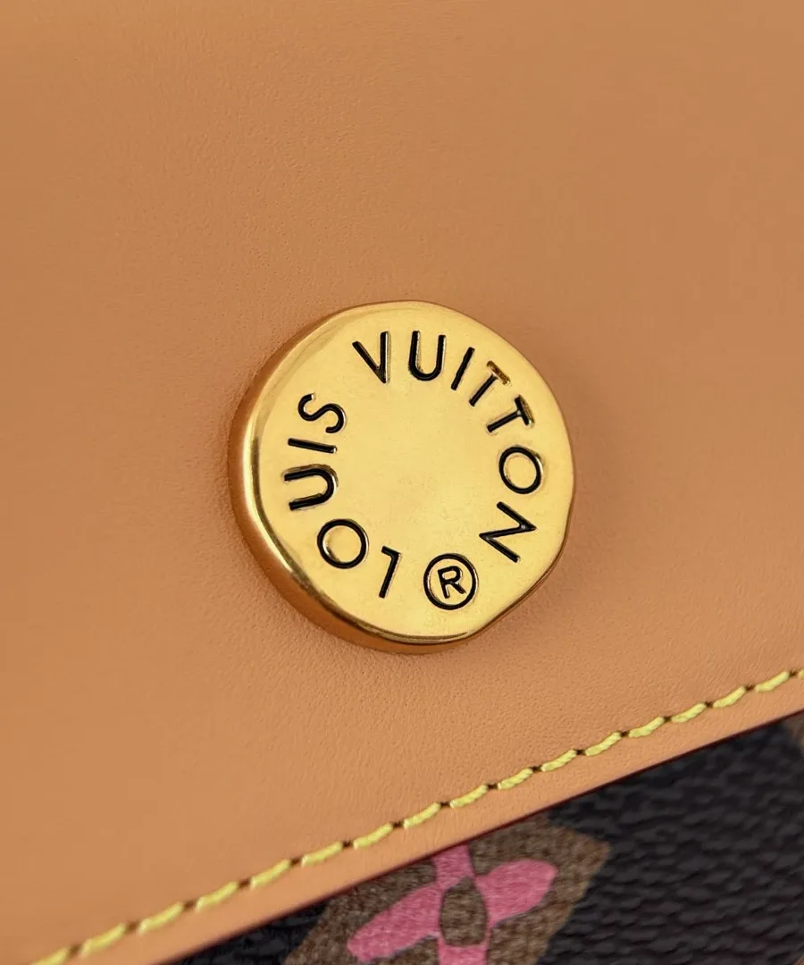 Крупный план золотистой кнопки-застежки с гравировкой Louis Vuitton