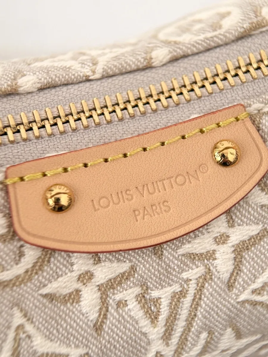 Крупный план золотистой молнии и кожаной нашивки с тиснением Louis Vuitton Paris