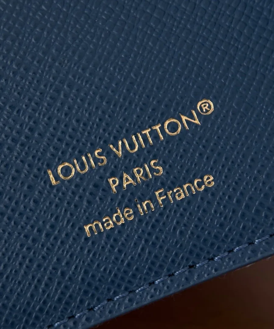 Крупный план золотистого тиснения Louis Vuitton Paris внутри кошелька