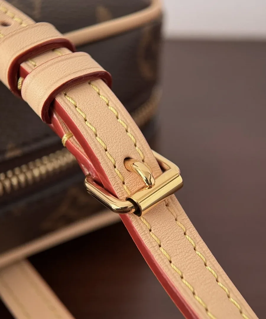 Золотистая пряжка на кожаном плечевом ремне сумки Louis Vuitton