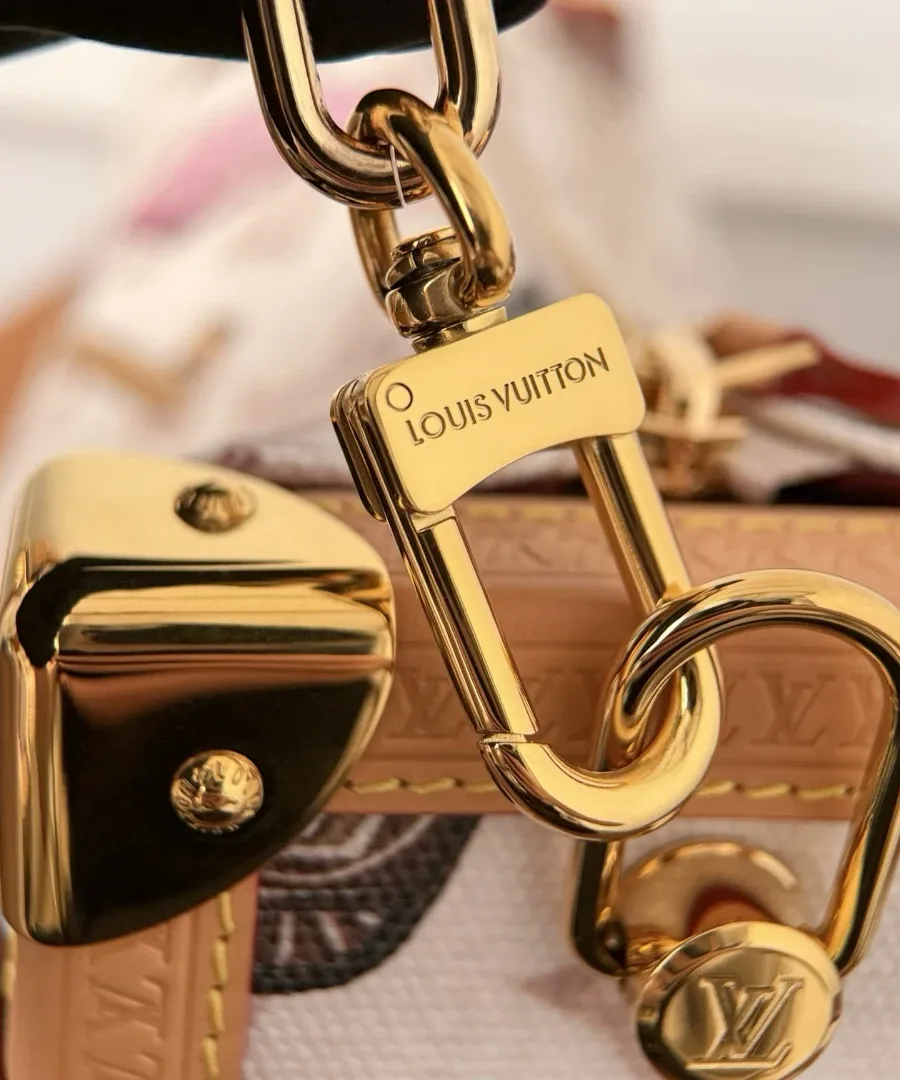Золотистый карабин с гравировкой Louis Vuitton крупным планом