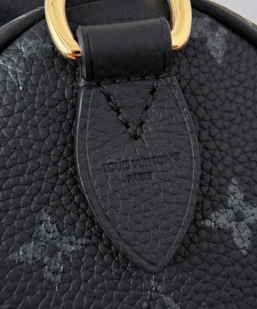 Крупный план кожаного крепления ручки с тиснением Louis Vuitton