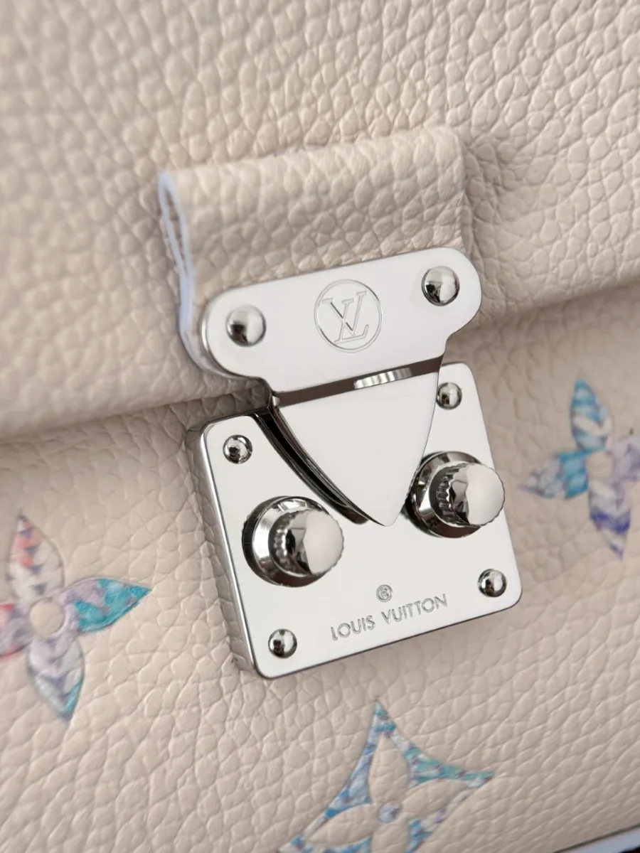 Крупный план серебристого замка S-lock на клапане сумки Louis Vuitton