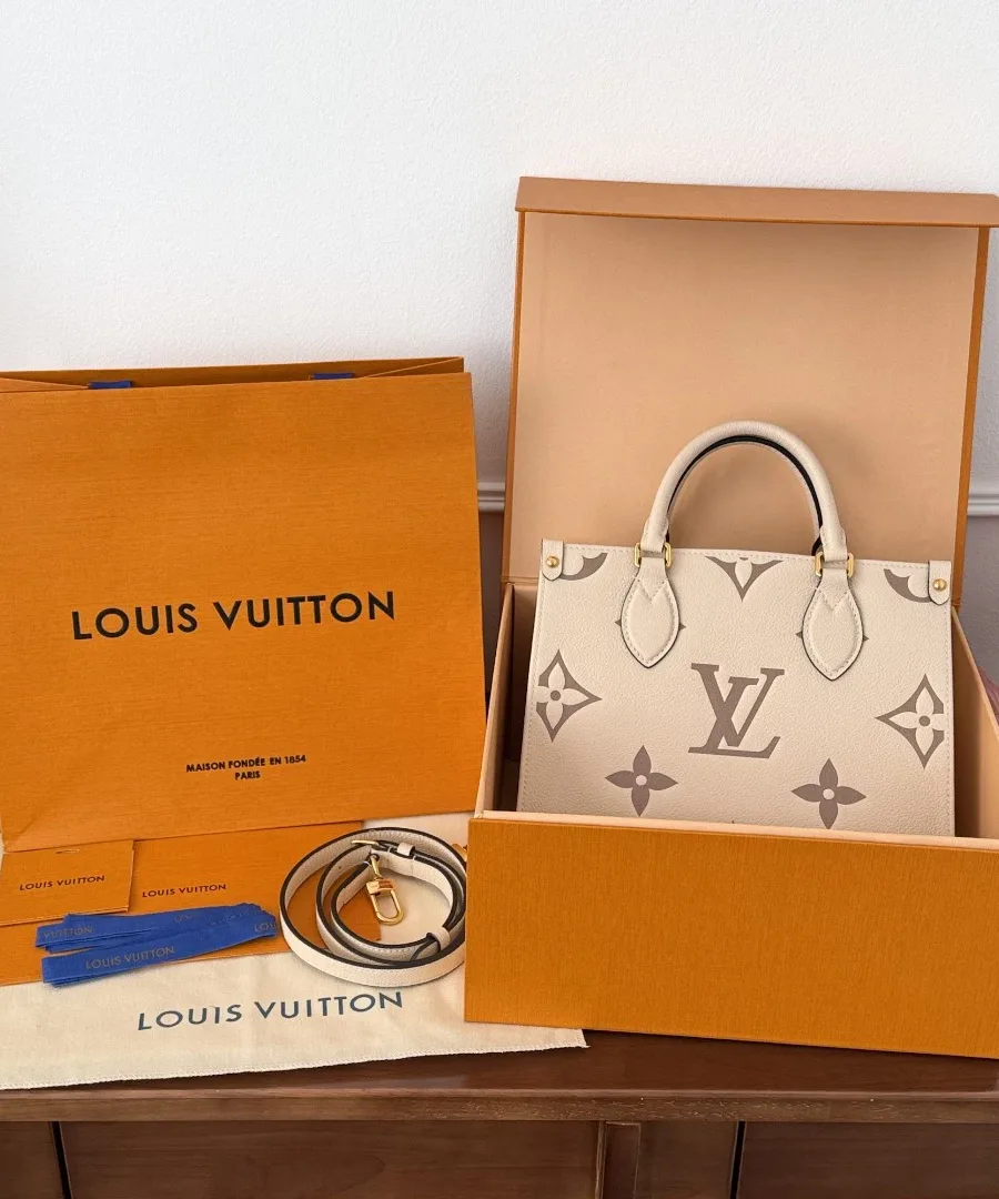 Сумка OnTheGo PM рядом с фирменной коробкой и пакетом Louis Vuitton