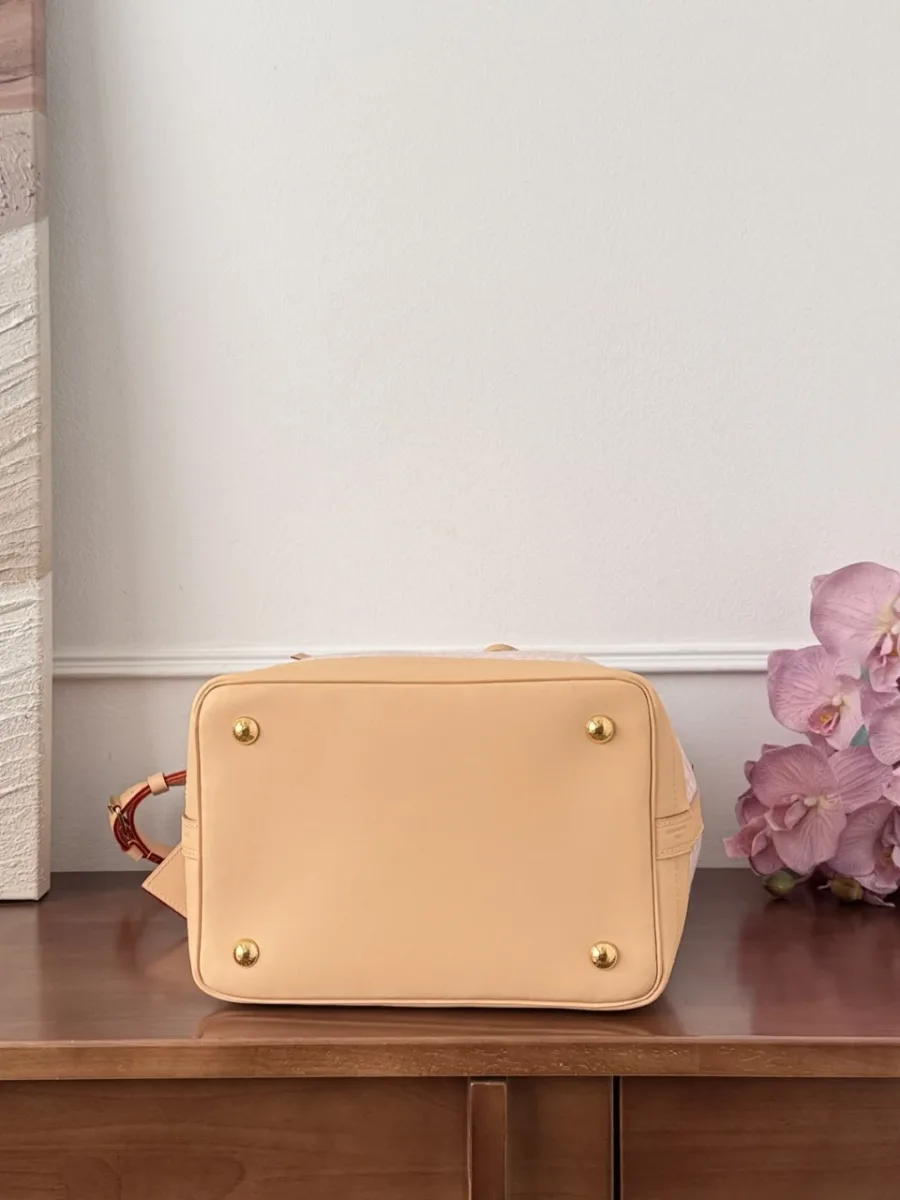 Бежевое кожаное дно сумки Louis Vuitton Noé с четырьмя золотистыми ножками