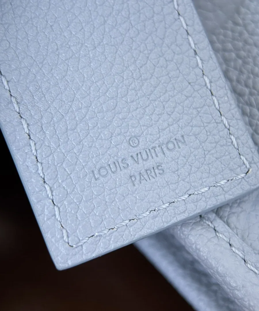 Тиснение Louis Vuitton Paris на кожаном ярлыке голубой сумки