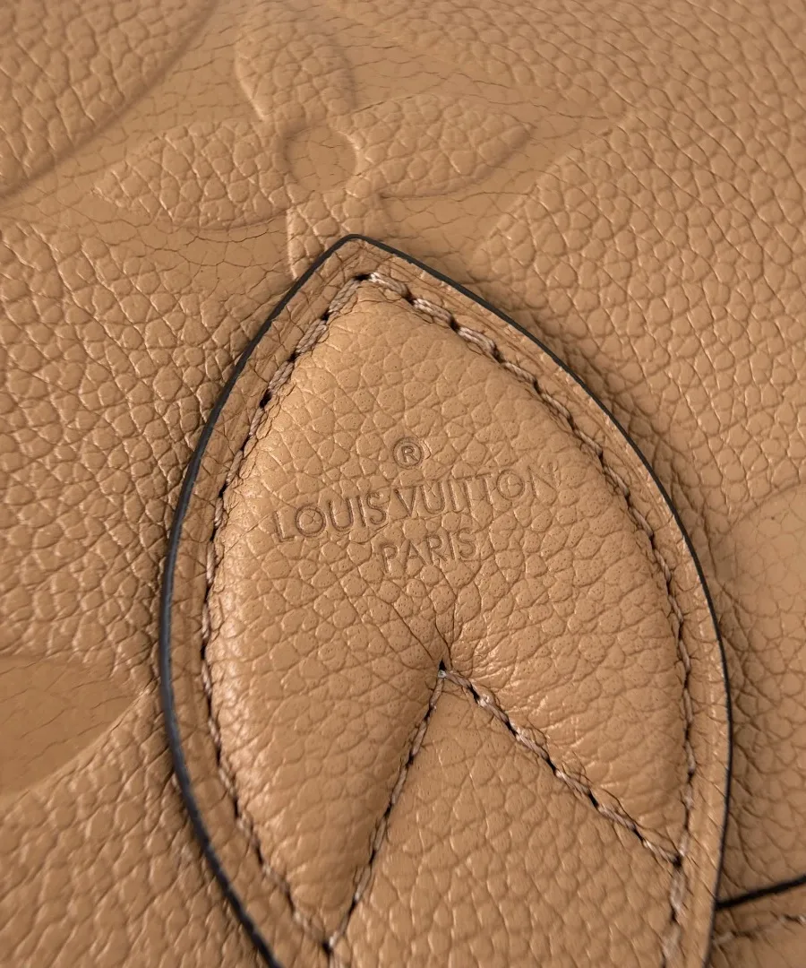 Крупный план тисненой кожи Monogram Empreinte и кожаной детали сумки