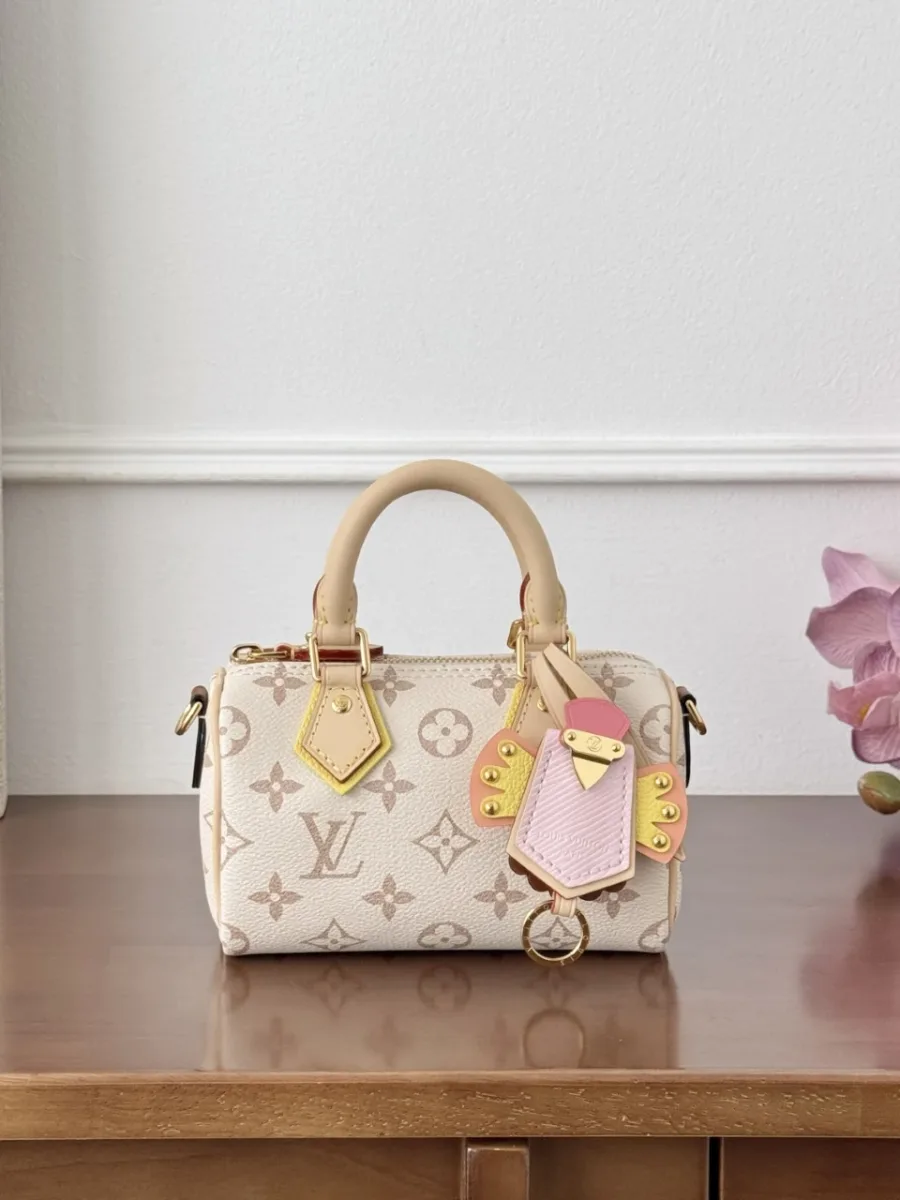 Мини-сумка Louis Vuitton Nano Speedy молочно-белого цвета с цветным брелоком, вид спереди