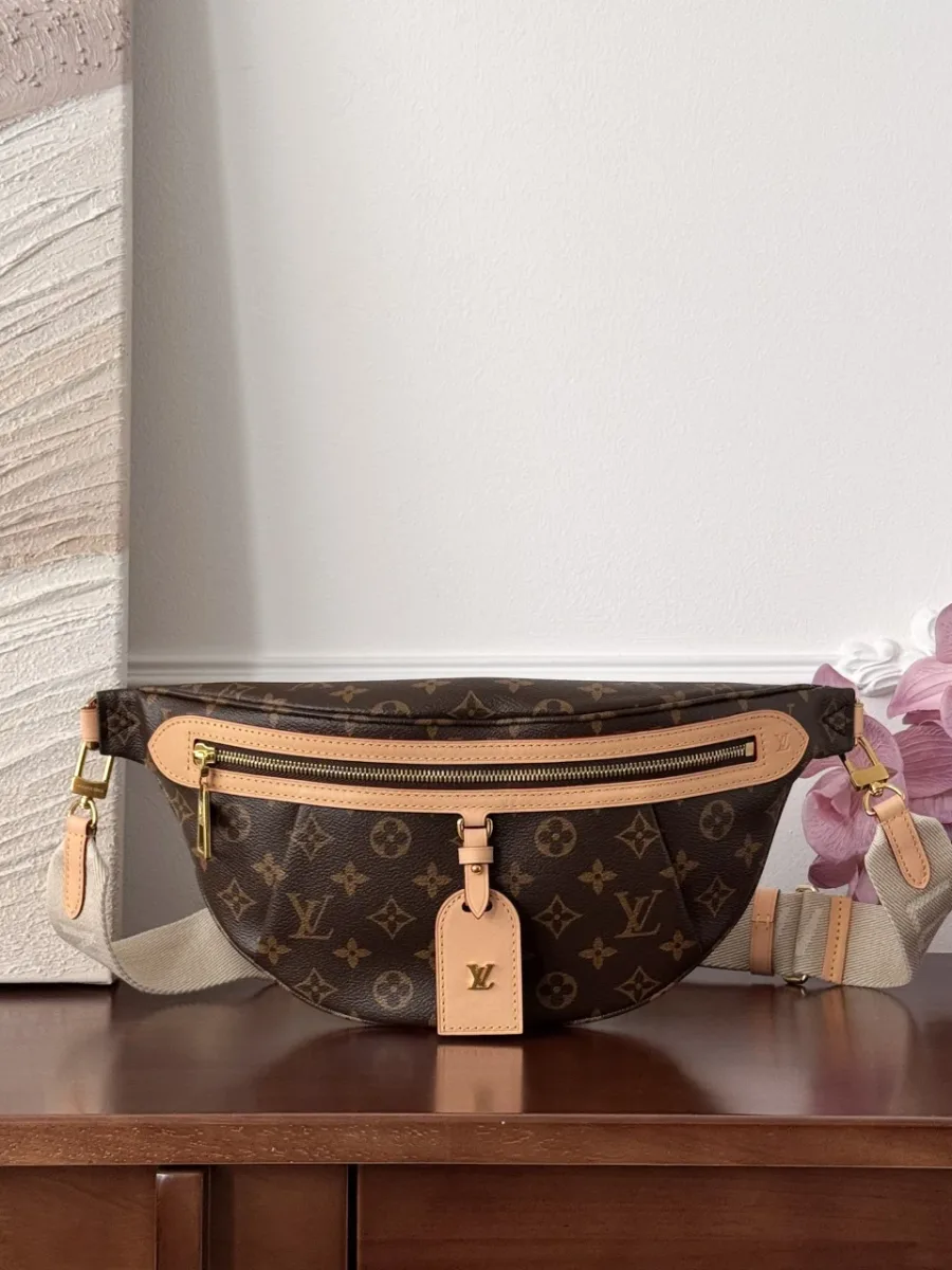 Поясная сумка Louis Vuitton Bumbag из канвы Monogram, вид спереди на деревянном столе.