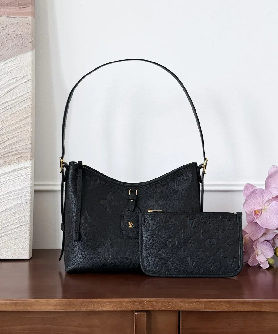 Чёрная кожаная сумка CarryAll PM со съёмным клатчем на деревянном столе