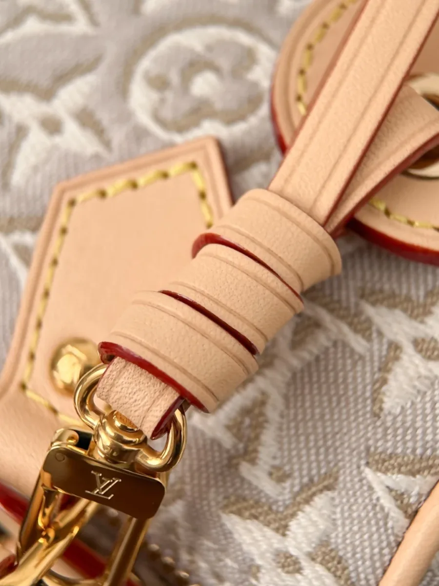 Крупный план крепления плечевого ремня к сумке Louis Vuitton