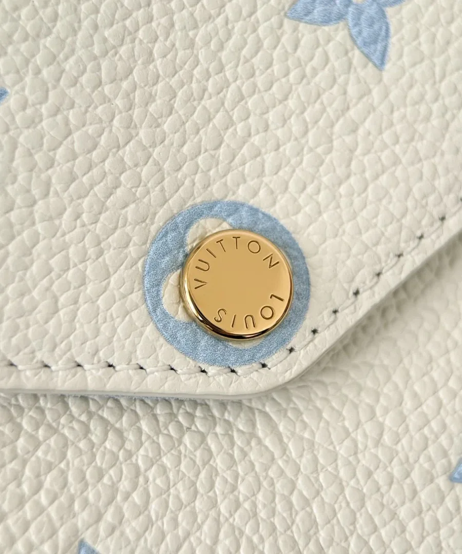 Крупный план золотистой кнопки-застежки с гравировкой Louis Vuitton