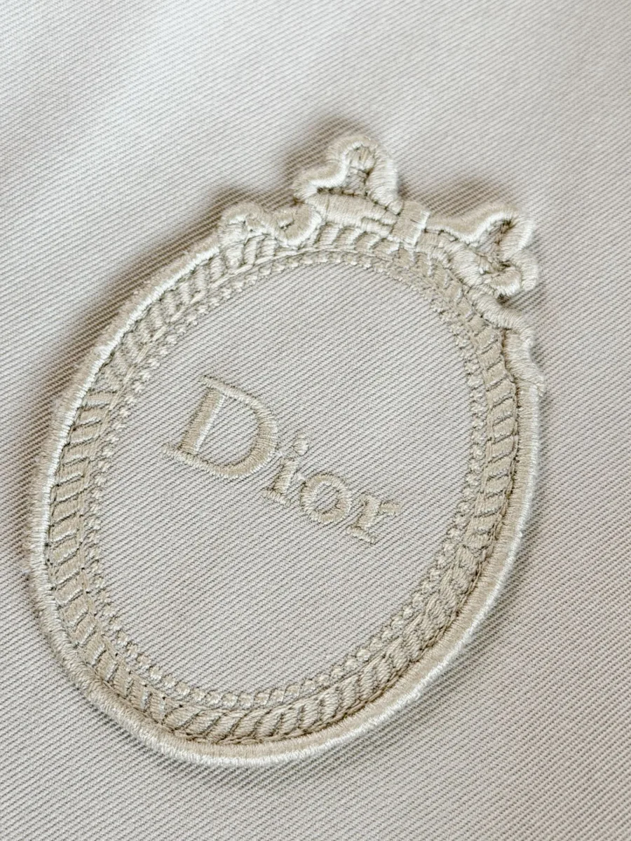 Вышитая эмблема-медальон с надписью Dior на груди крупным планом