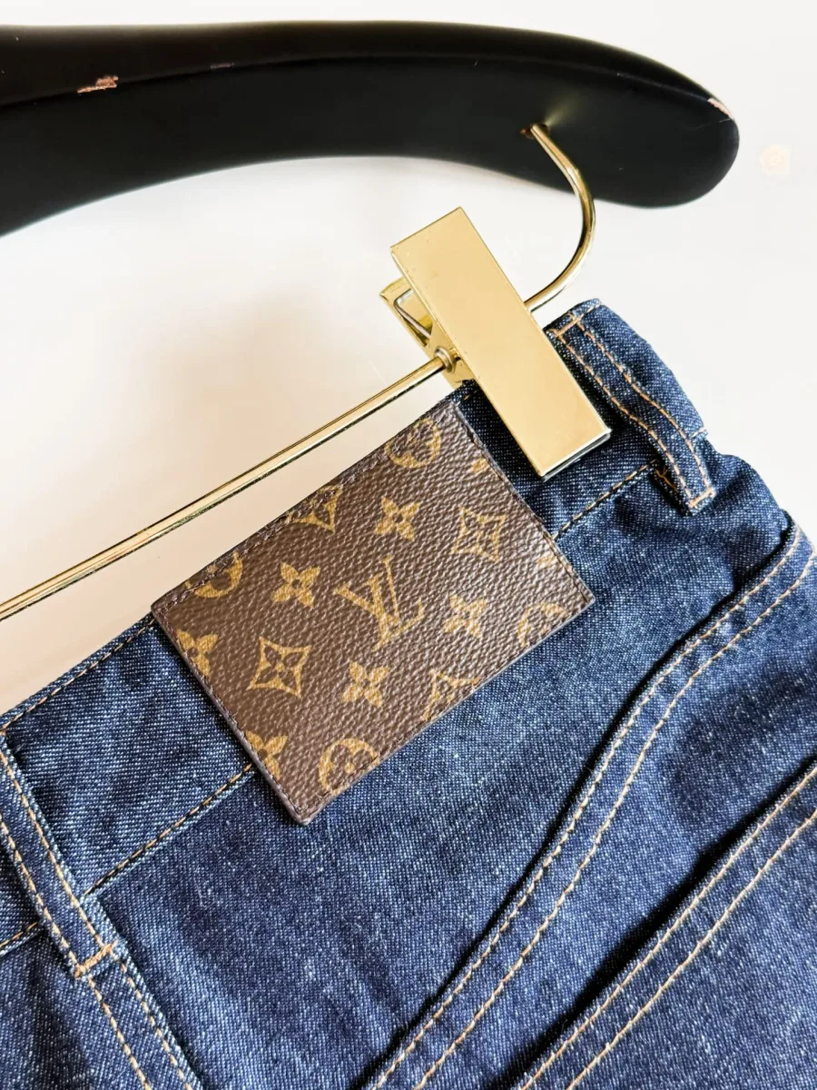 Патч из канваса Monogram на поясе джинсовых шорт крупным планом
