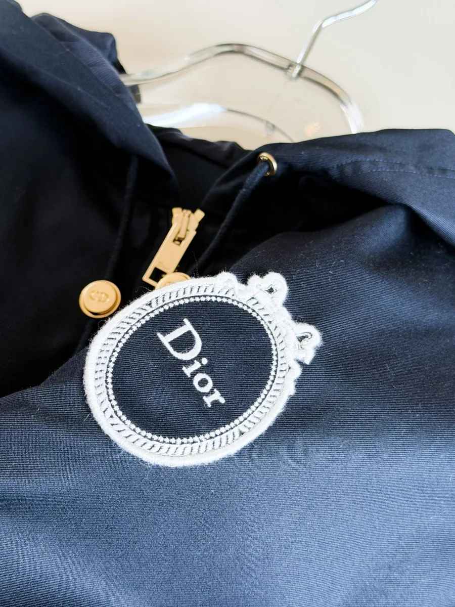 Крупный план овальной вышивки Medallion с логотипом Dior на груди