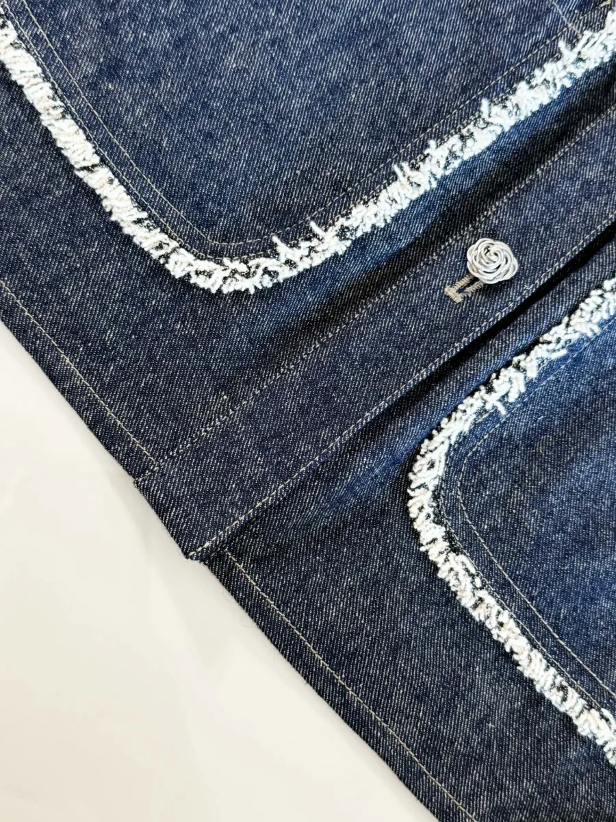 Планка на пуговицах и накладной карман джинсовой куртки с бахромой
