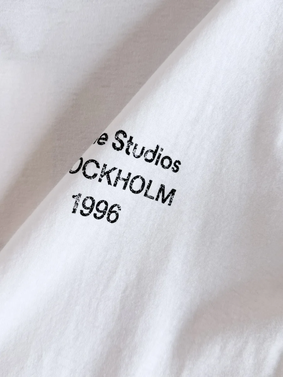 Макрофотография принтованной надписи Acne Studios Stockholm 1996 на ткани