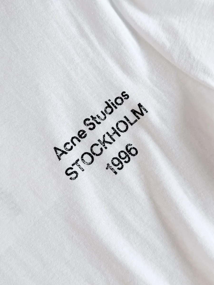 Контрастный чёрный принт Acne Studios Stockholm 1996 на груди крупным планом