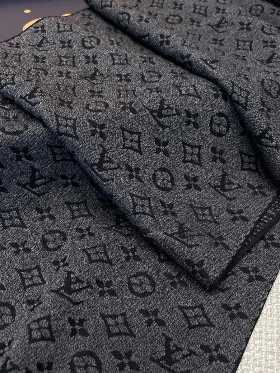 Крупный план серого шерстяного шарфа с жаккардовым паттерном Monogram