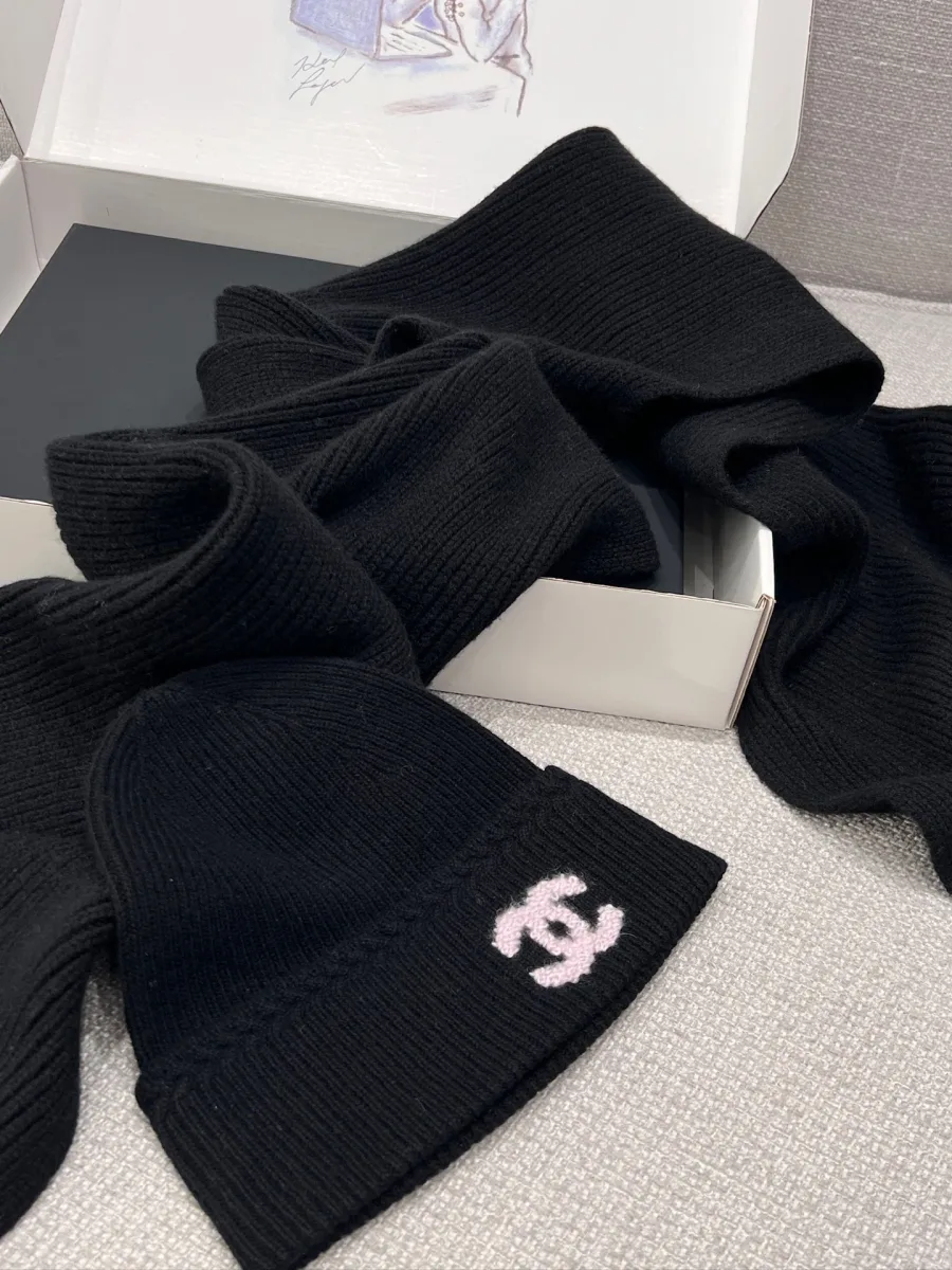 Чёрный длинный шарф и шапка Chanel крупным планом на фоне коробки