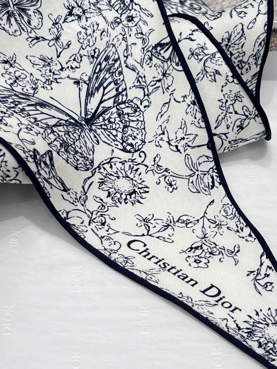 Заострённый край платка с надписью Christian Dior и рисунком бабочки