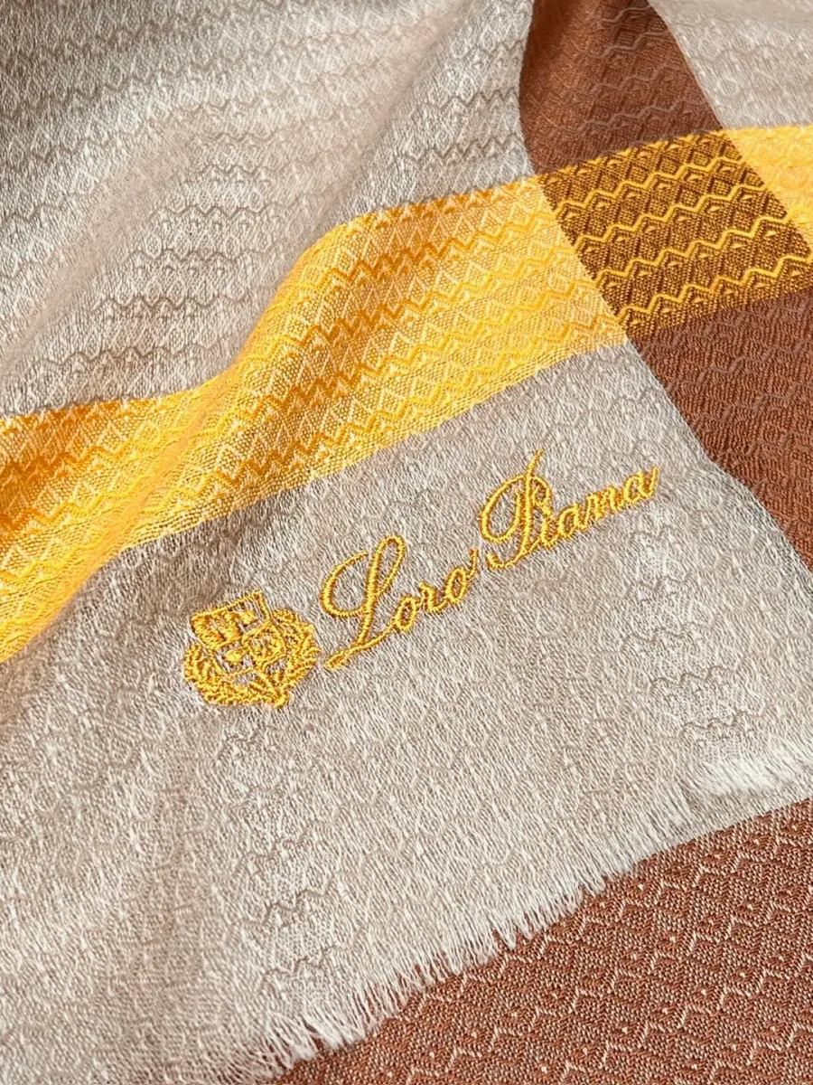 Вышитый золотистый логотип Loro Piana на углу шарфа с бахромой