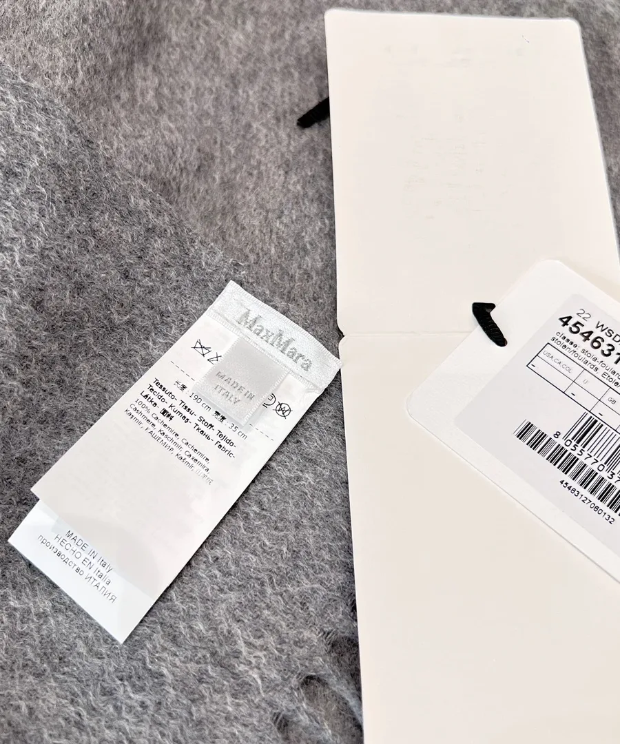 Бирка бренда Max Mara и ярлык с информацией об уходе на сером шарфе