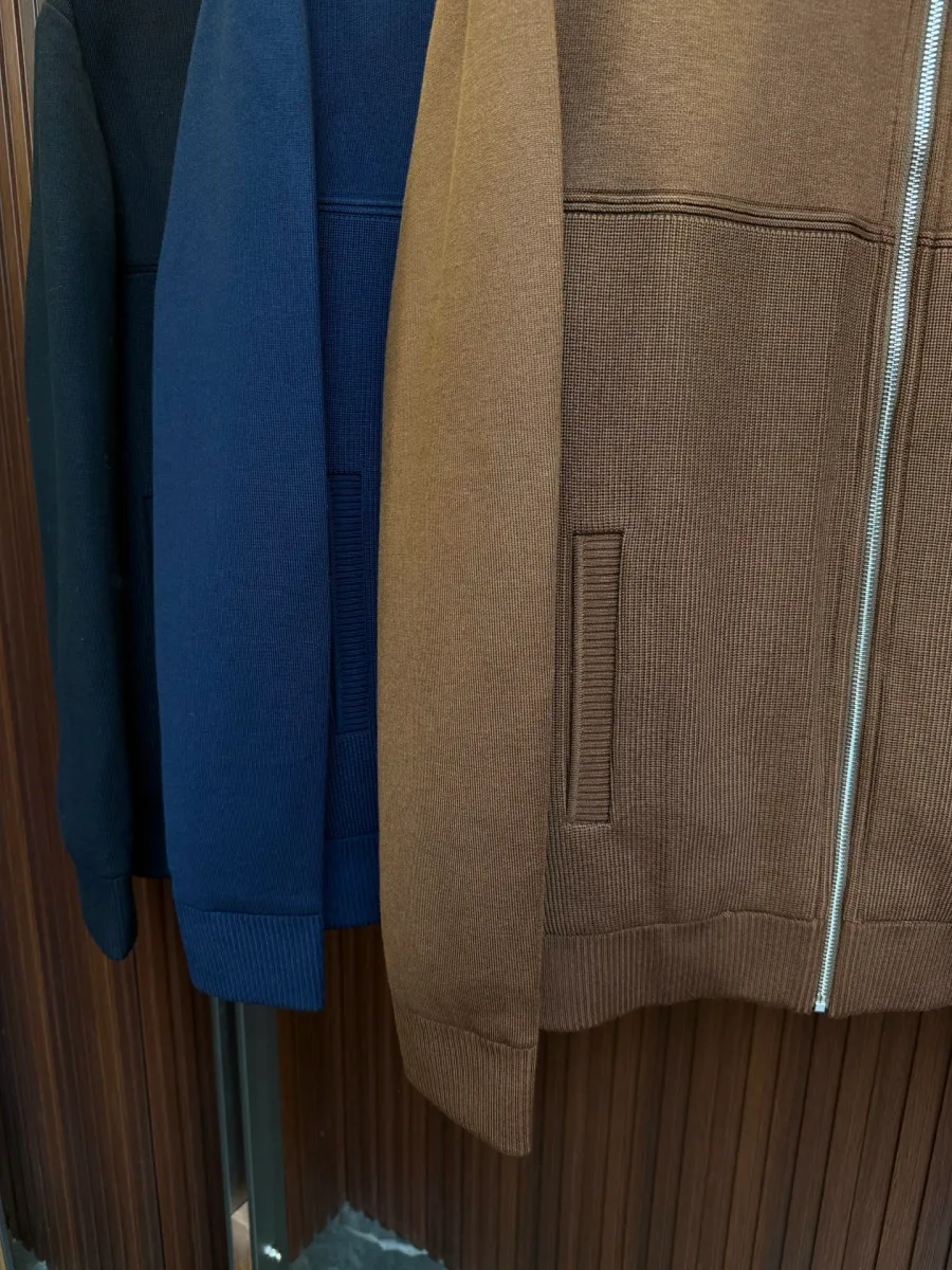 Коричневый пуховик Zegna, крупный план трикотажной фактуры, прорезного кармана и молнии