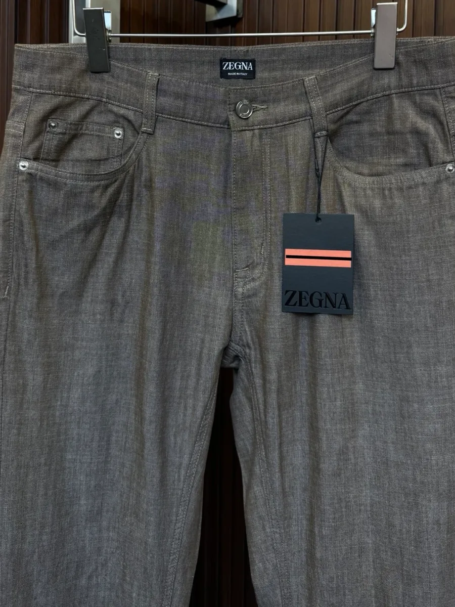 Верхняя часть коричневых брюк Zegna с карманами, поясом со шлёвками и брендовой биркой