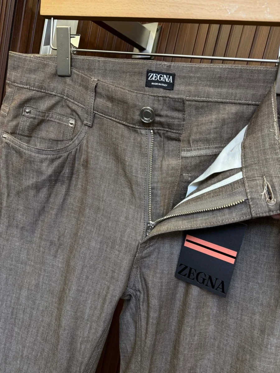 Застёжка коричневых брюк Zegna на металлическую молнию и пуговицу крупным планом