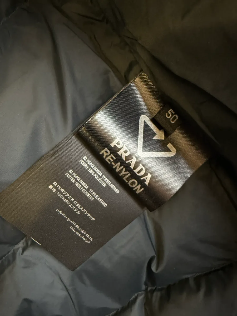 Внутренняя тканевая бирка Prada Re-Nylon с логотипом треугольника и указанием размера 50