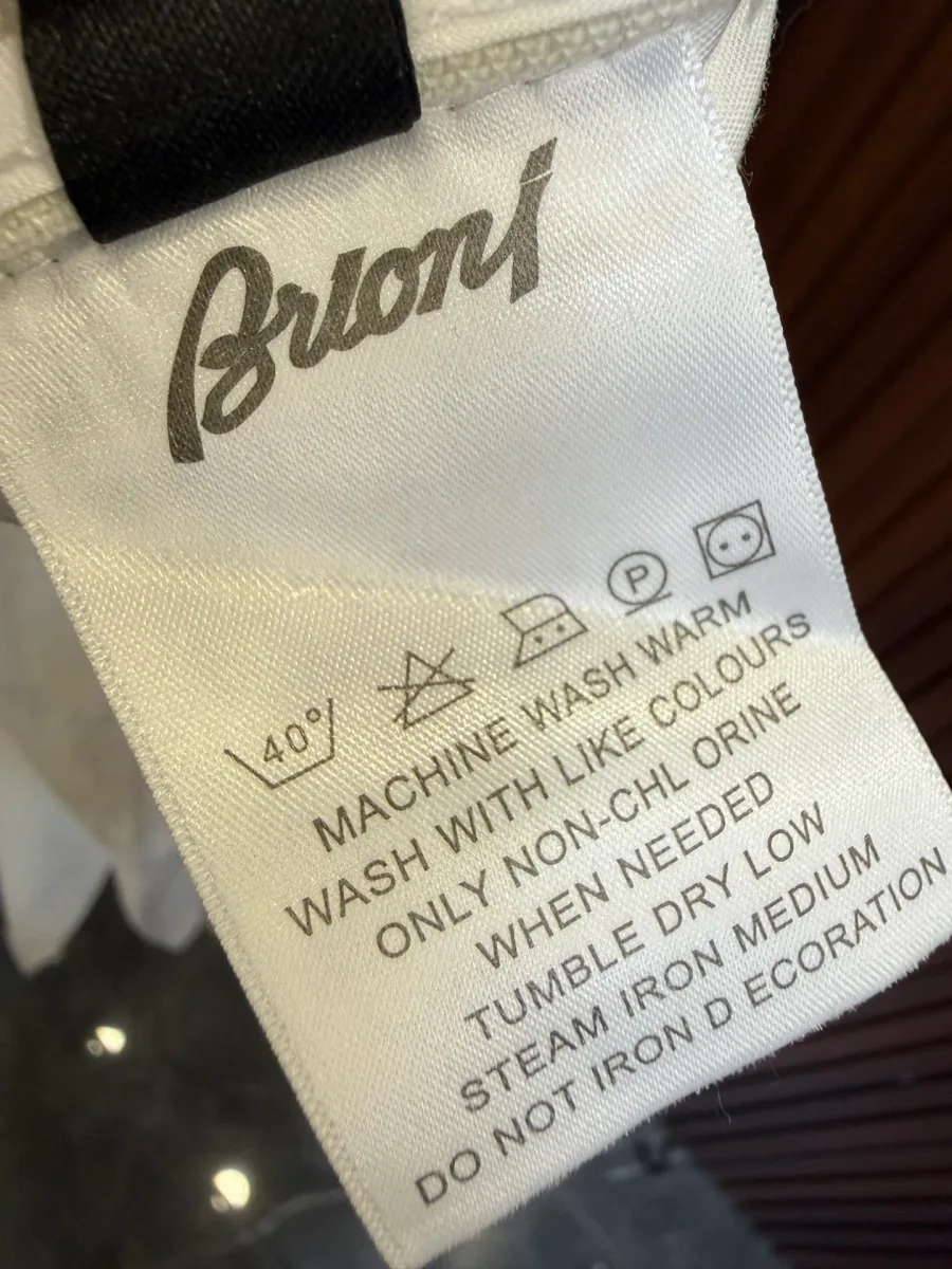 Фирменный тканевый ярлык Brioni с курсивным логотипом и символами ухода