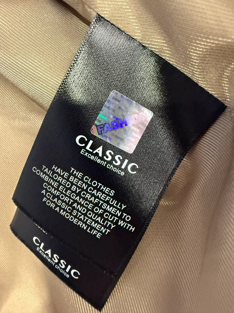 Текстильная бирка Classic с голографической наклейкой на подкладке изделия крупным планом