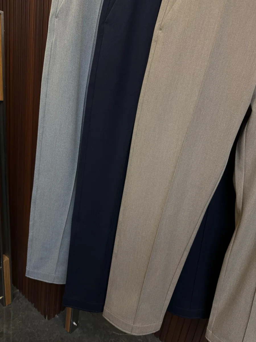 Нижний край штанин трёх пар брюк Zegna в сером, синем и бежевом цветах