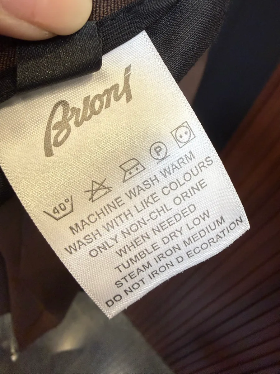 Тканевый ярлык с логотипом Brioni и рекомендациями по уходу за изделием