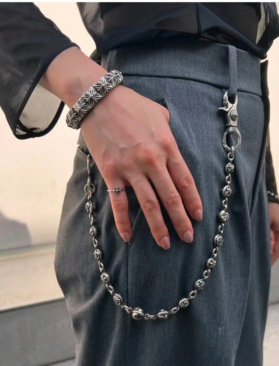 Цепь Chrome Hearts из серебра, надетая на шлевки серых брюк