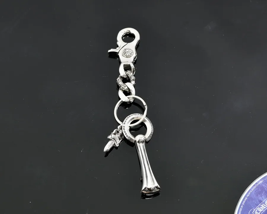 Серебряный брелок Chrome Hearts с карабином и подвесками на черном фоне