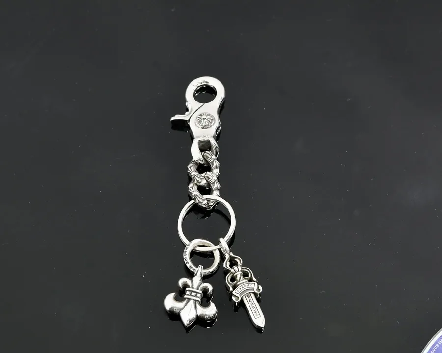 Серебряный брелок Chrome Hearts с карабином и подвесками Fleur и Dagger на темном фоне