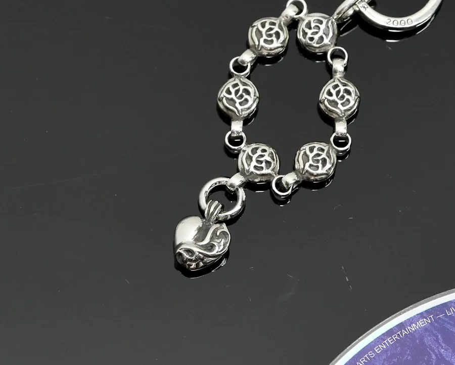 Детали резных звеньев и подвески-сердца серебряного кулона Chrome Hearts крупным планом