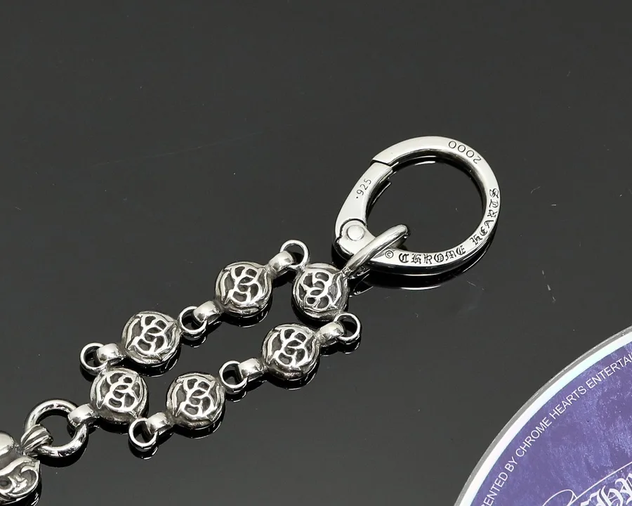 Крупный план круглого карабина с гравировкой и звеньев кулона Chrome Hearts
