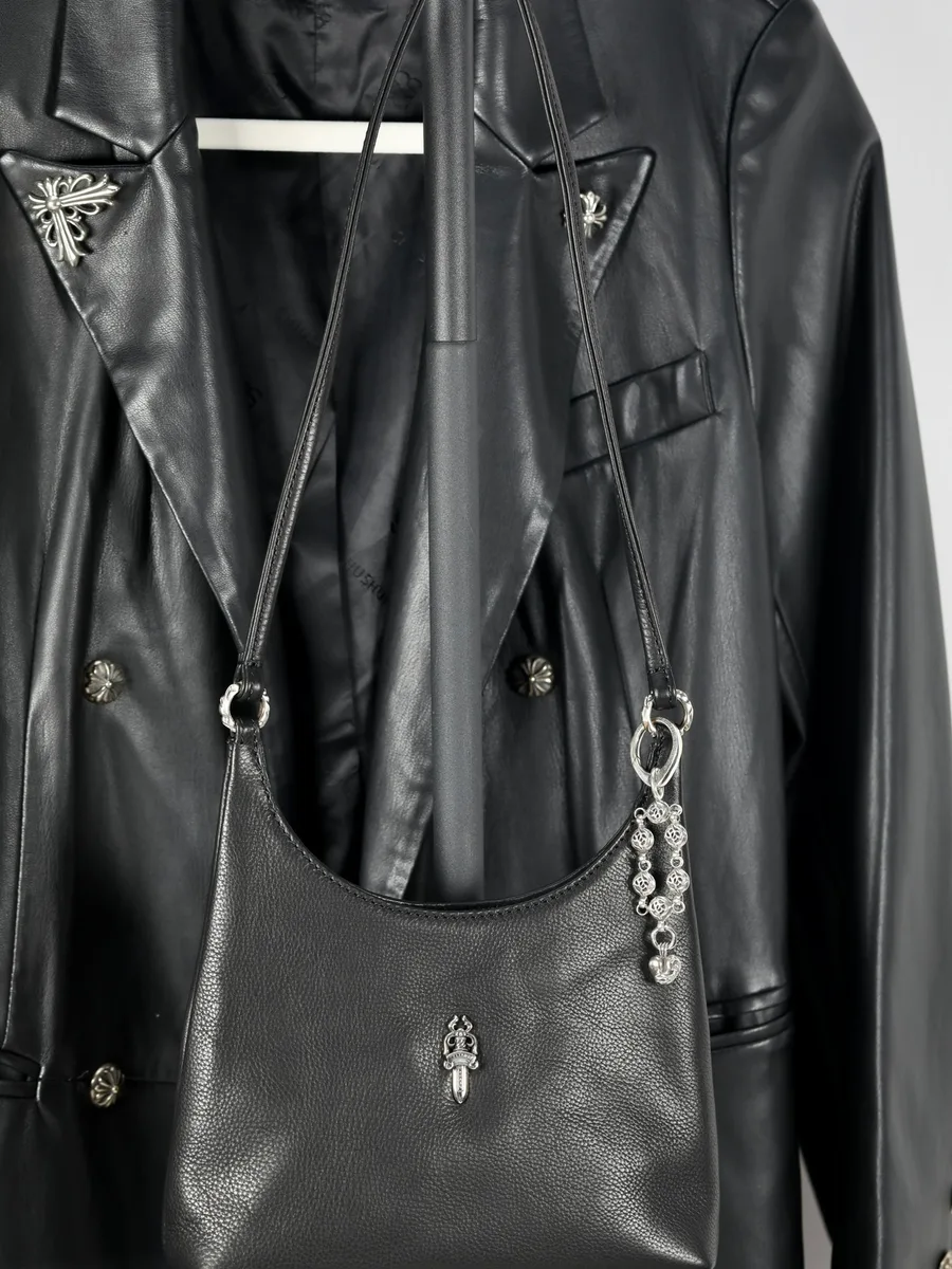 Черная кожаная сумка с серебряным кулоном-цепочкой Chrome Hearts на манекене