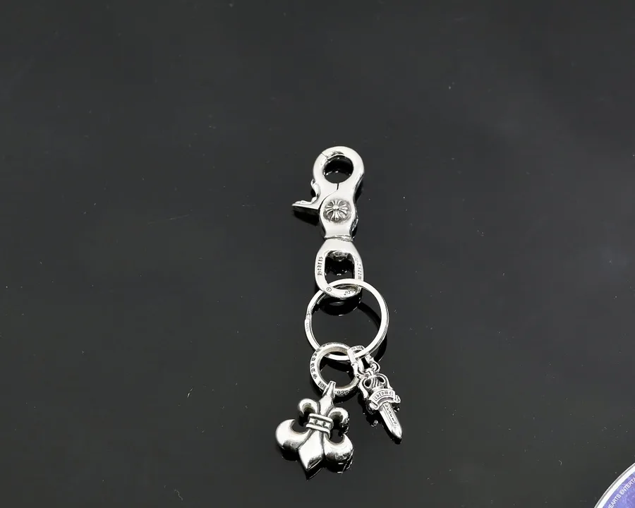 Серебряный брелок Chrome Hearts с карабином и подвесками Fleur и Dagger на темном фоне