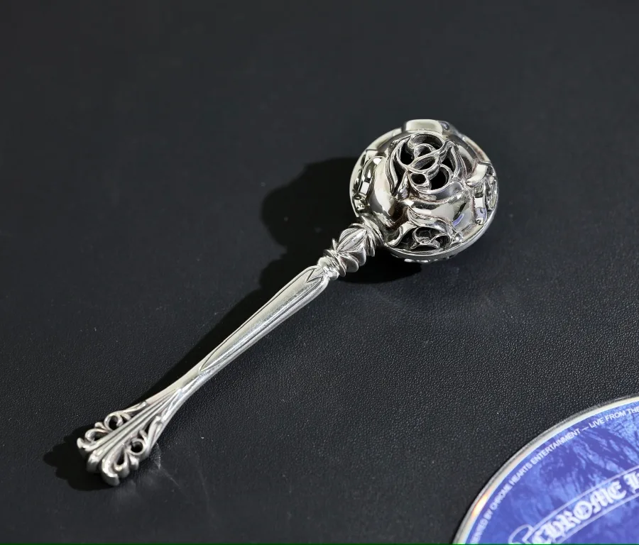 Серебряная детская погремушка Chrome Hearts Baby Rattle на темном фоне