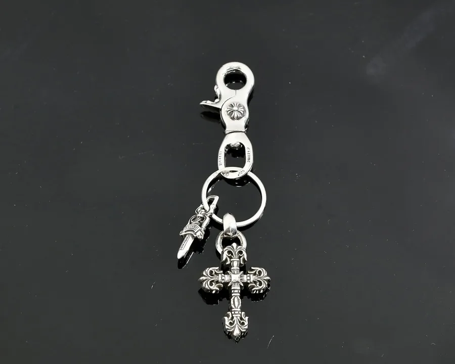 Серебряный брелок Chrome Hearts с карабином, кольцом и подвесками в виде кинжала и креста на черном фоне