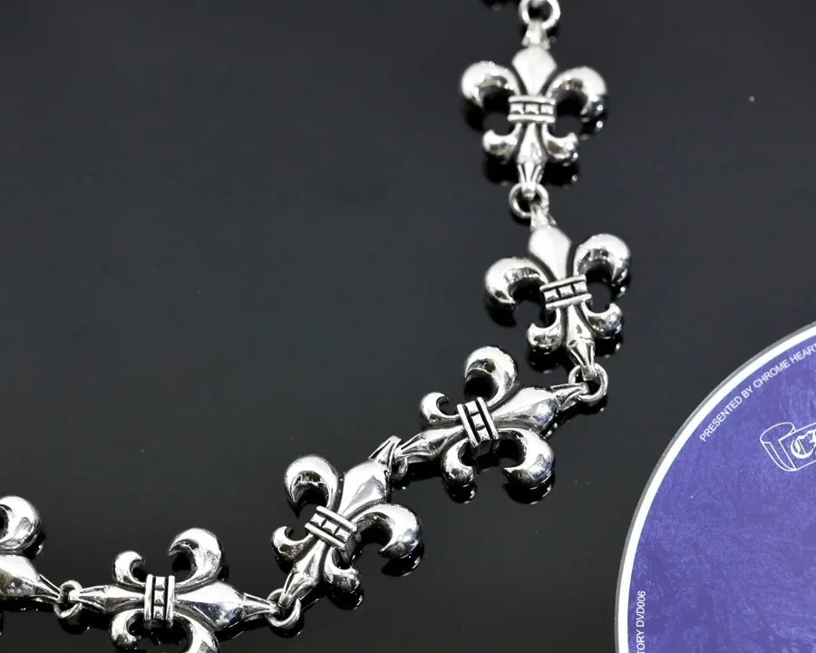 Крупный план звеньев серебряной цепи Chrome Hearts в виде лилий