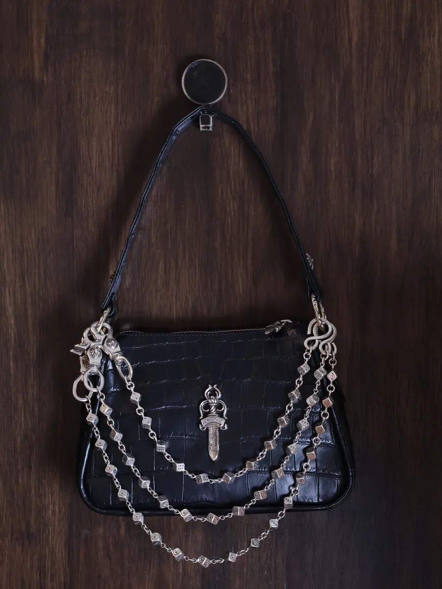 Пример ношения цепи Chrome Hearts Dice Chain на черной кожаной сумке