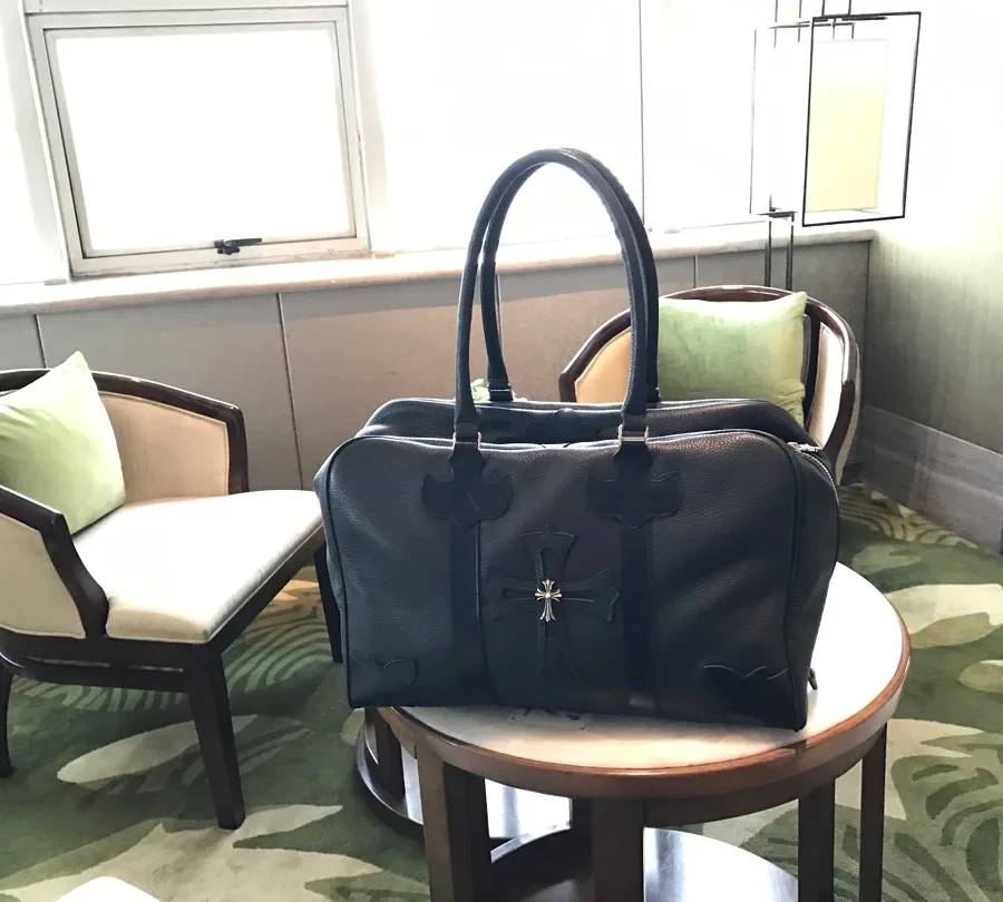 Вид сбоку черной кожаной сумки Chrome Hearts